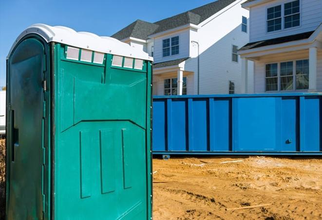 a line of portable bathrooms on a busy work site